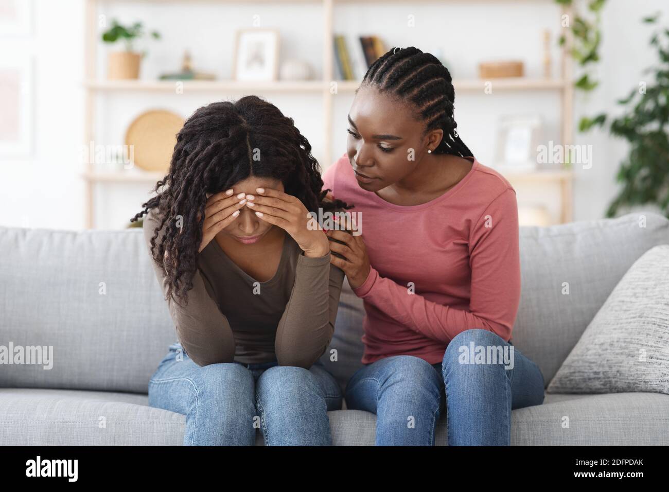 Attentive african american lady comforting her upset friend Stock Photo