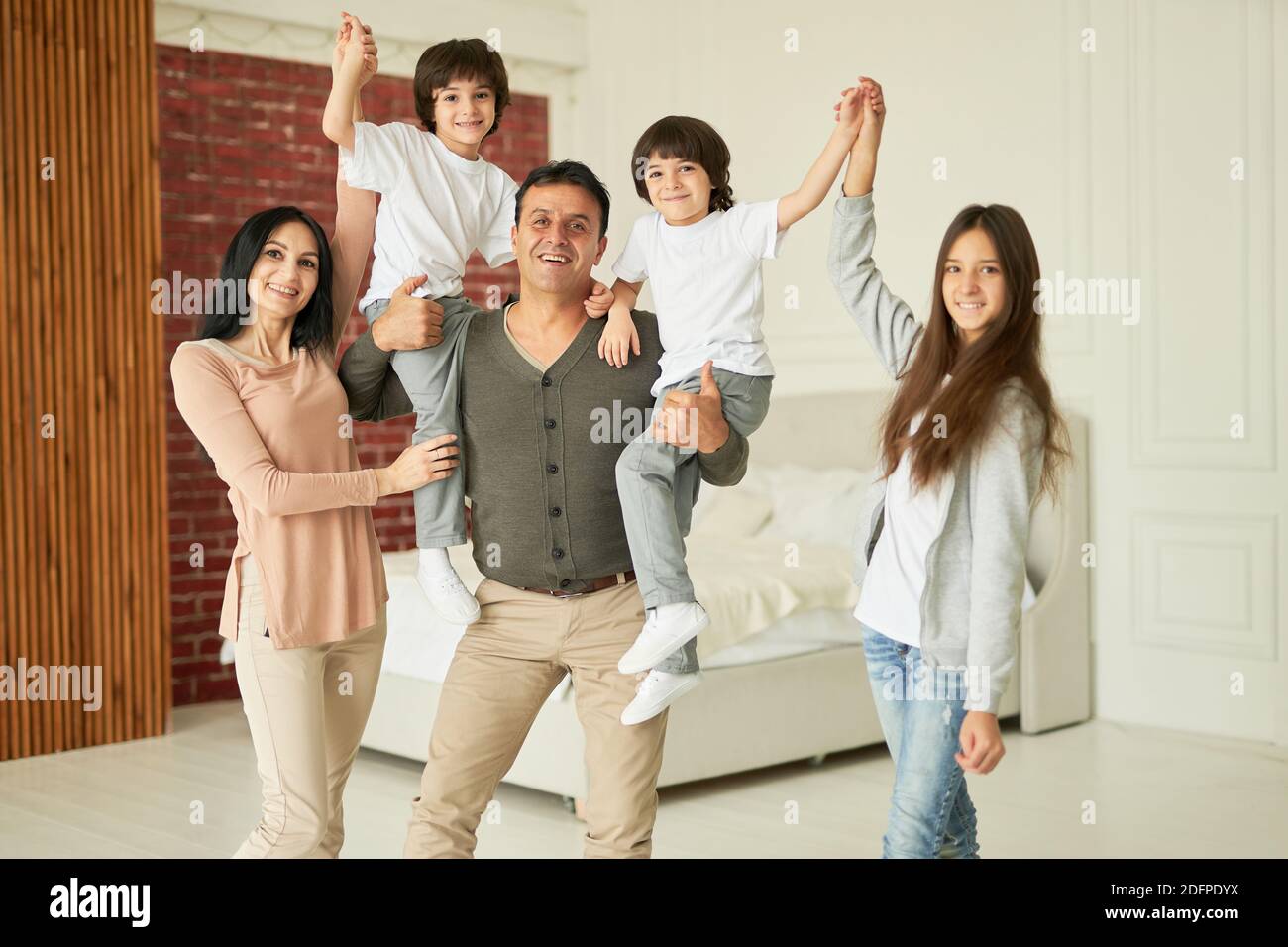 Portrait of happy latin family, parents, teenage girl and little twin