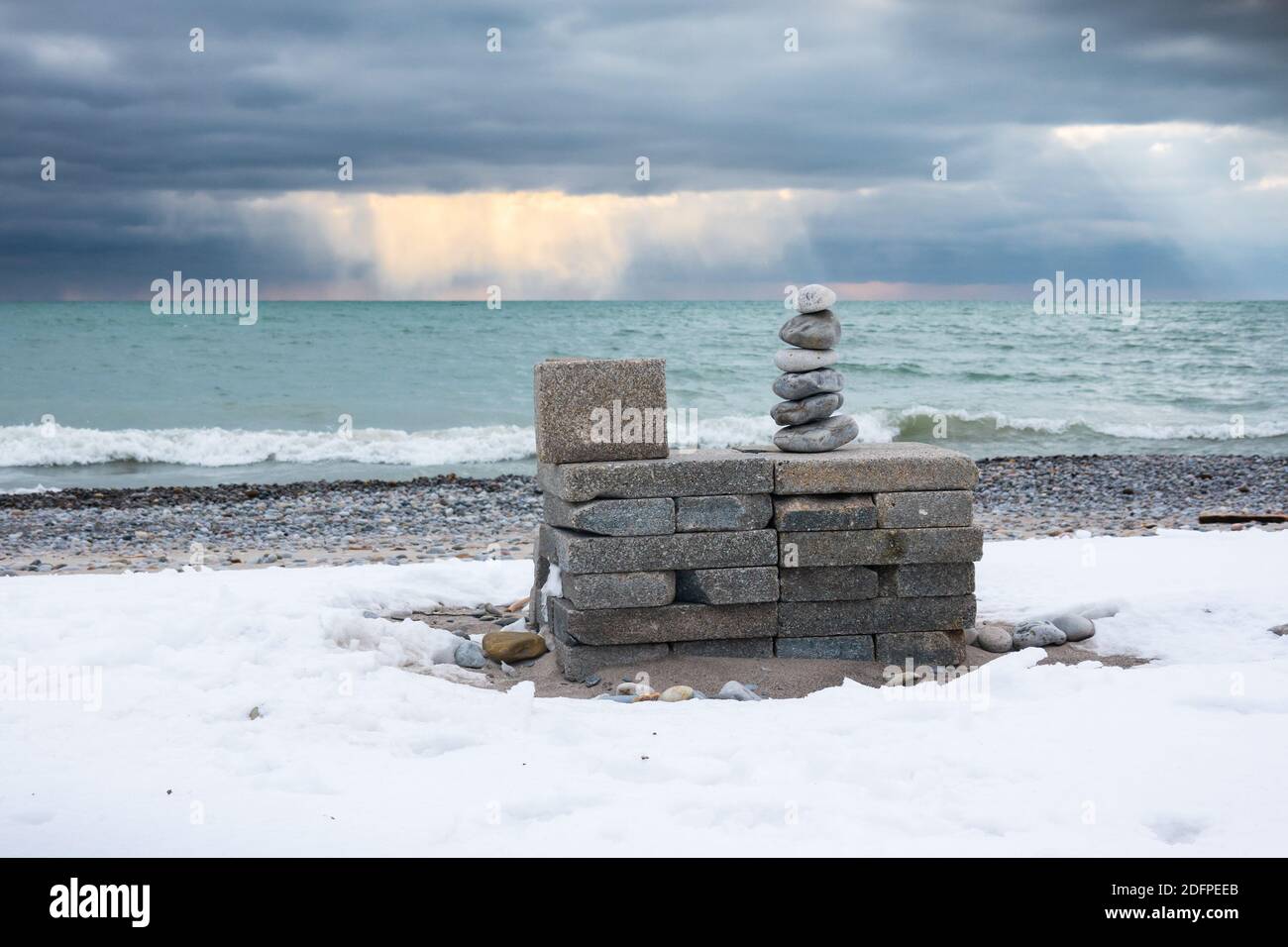 Stacked stones and dramatic skies on a cold winter day at Waterfront Park in Pickering, Ontario. Stock Photo