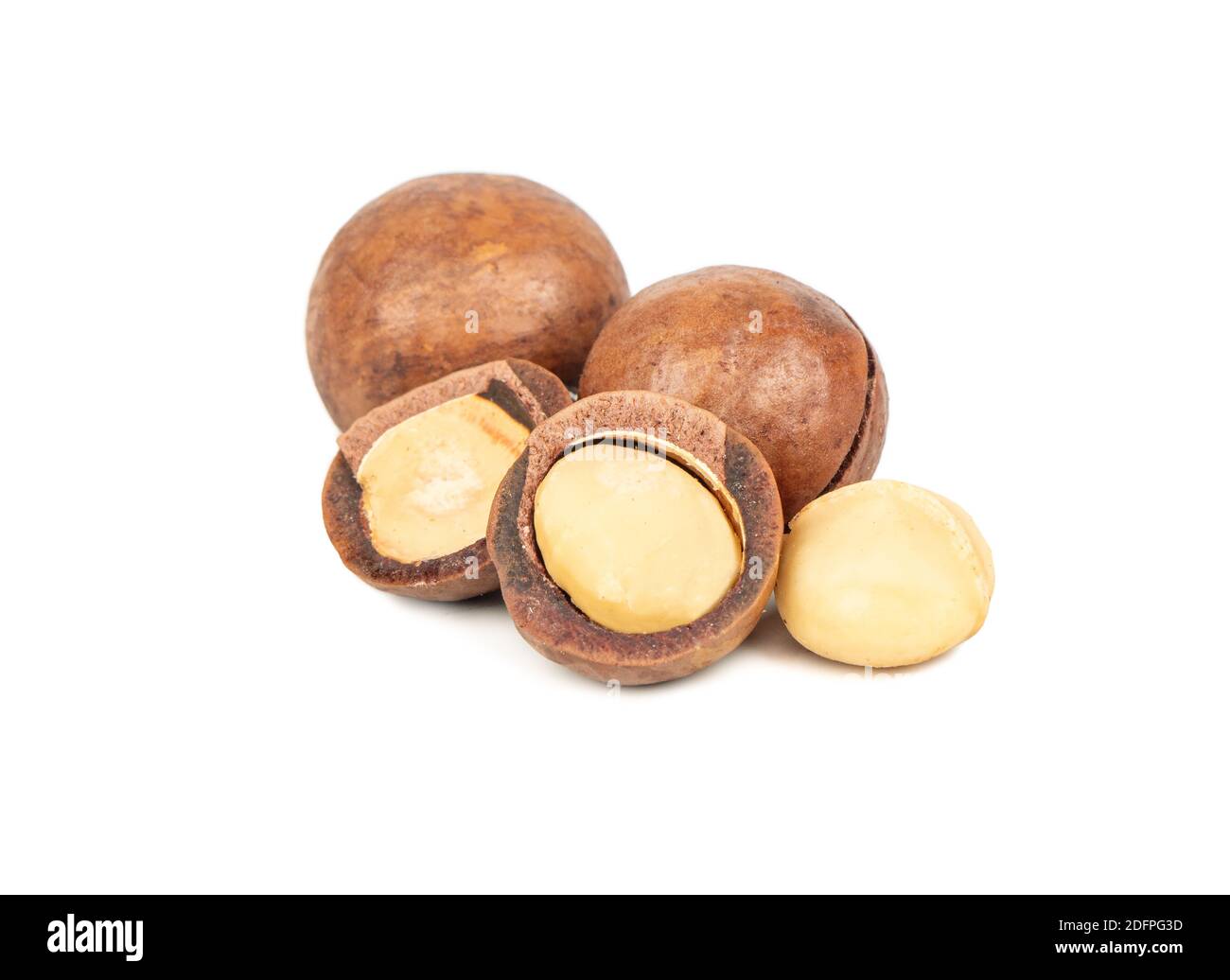 Split macadamia nuts with whole ones on a white background Stock Photo