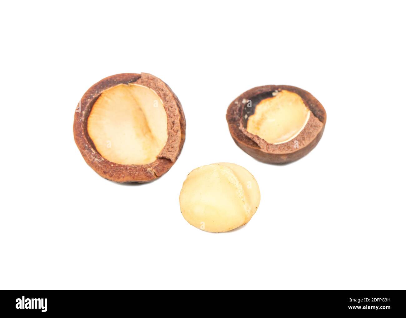 Split macadamia nuts with whole ones on a white background Stock Photo