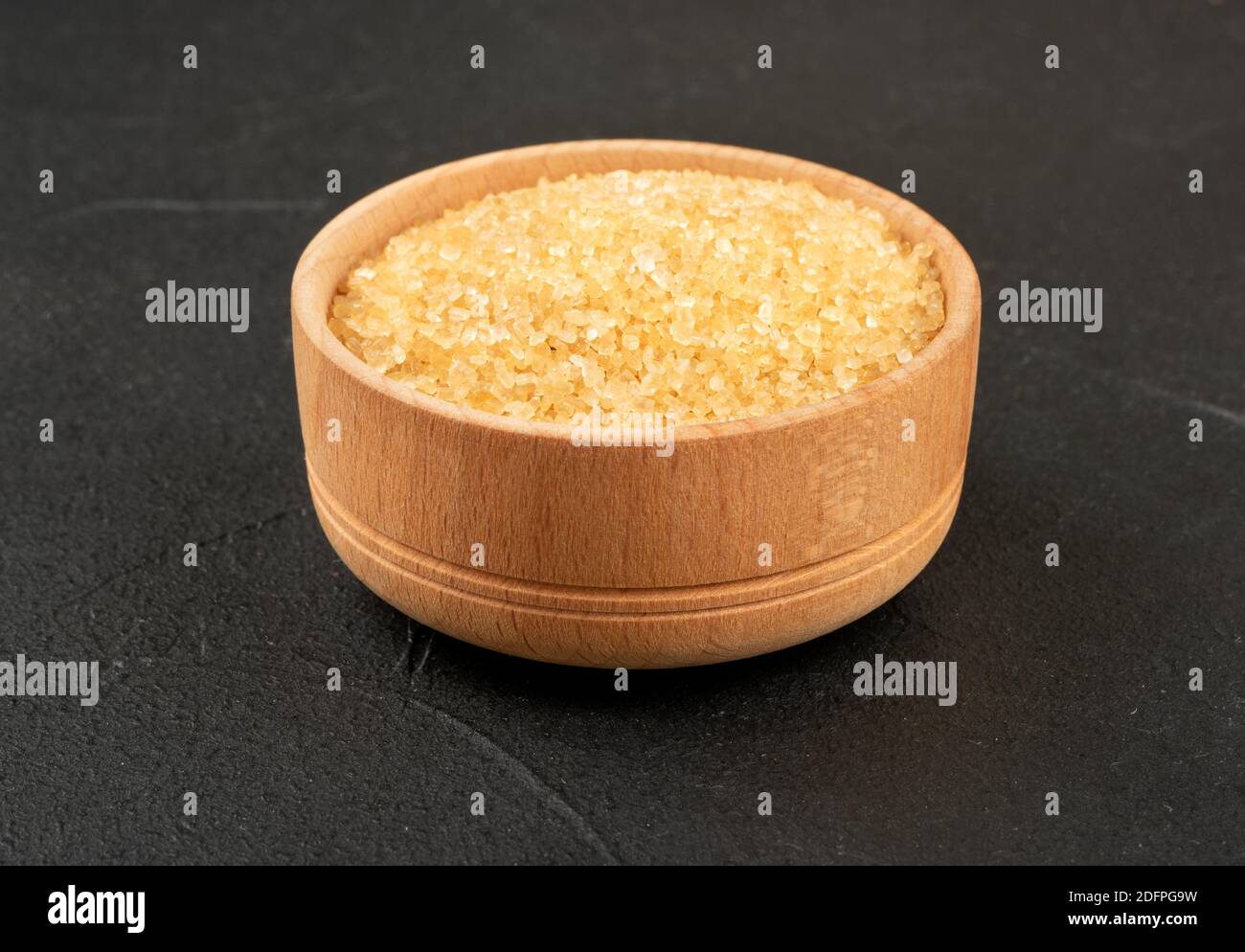 Wooden bowl with brown sugar on a concrete background Stock Photo