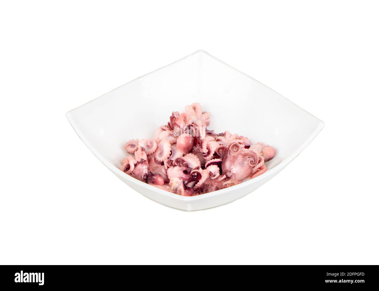 Small pickled octopus in a ceramic bowl on a white background Stock Photo