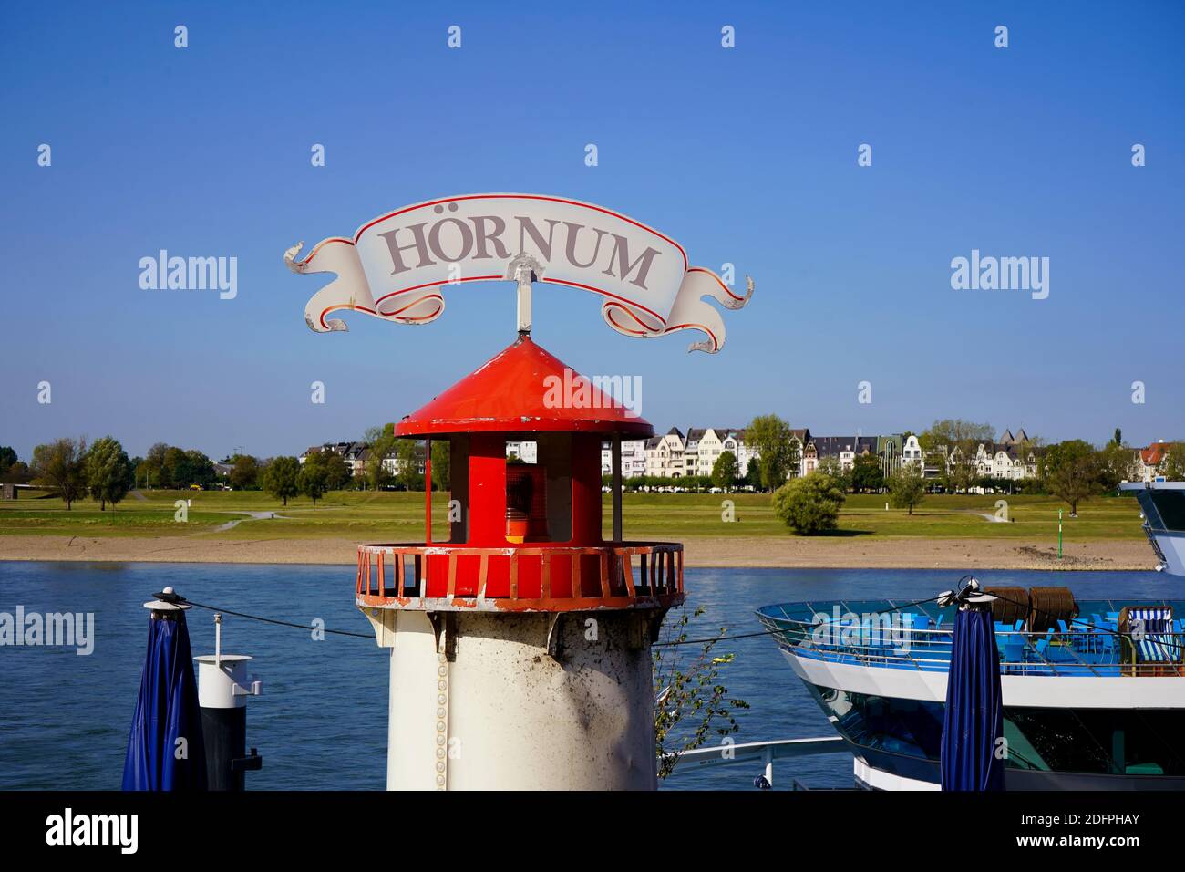 Decorational lighthouse in front of a fish restaurant at the Rhine river promenade on a beautiful sunny day. Stock Photo