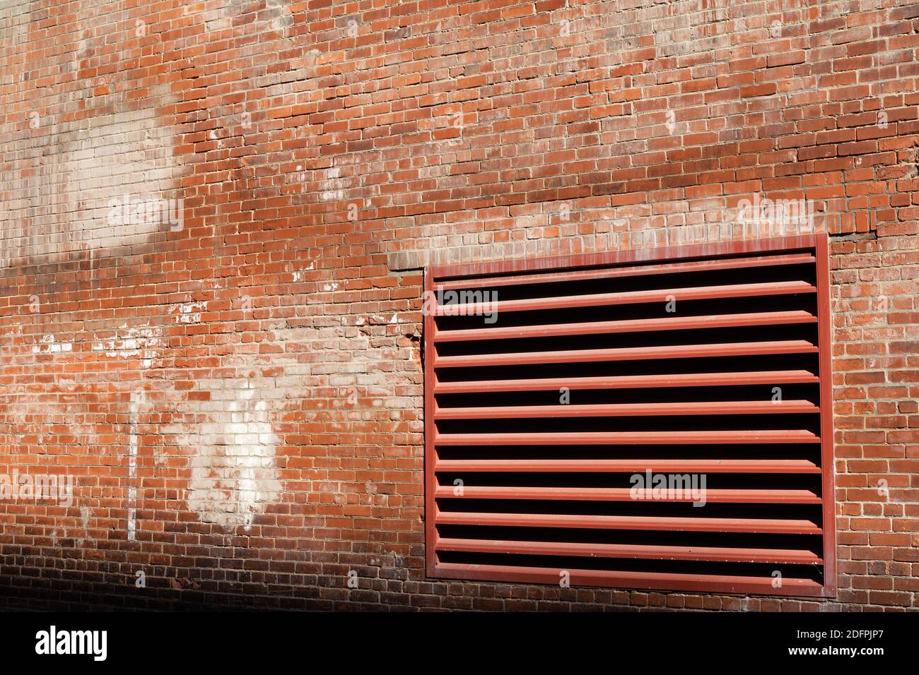 Angled view of weathered brick wall of an old industrial building with