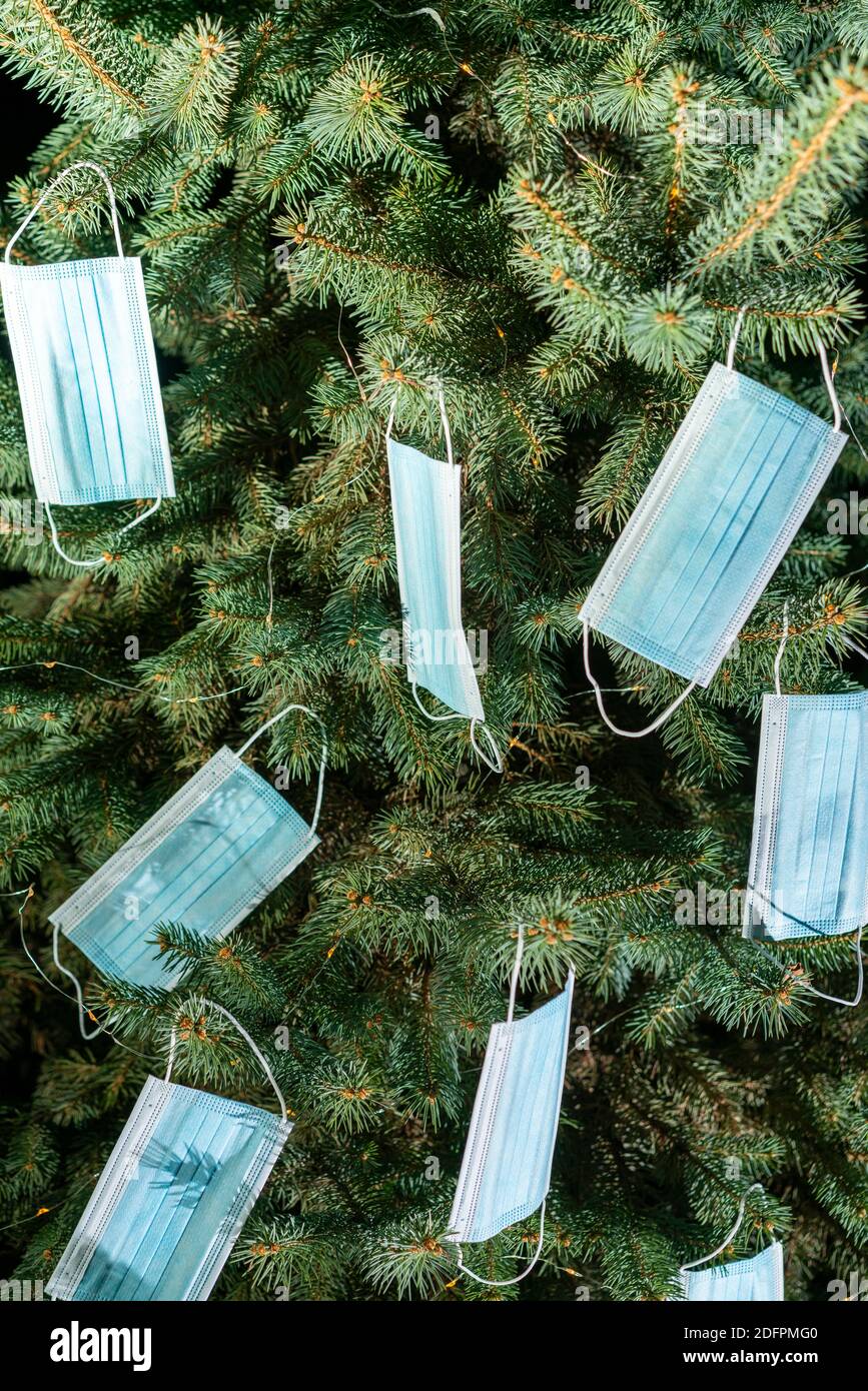 Christmas tree decorated with medical disposable medical masks. Celebrating new 2021 year during Covid-19 pandemic. vertical photo Stock Photo