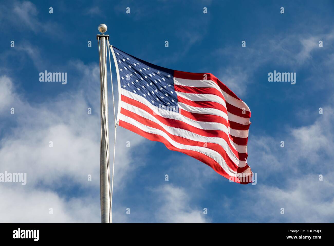 American flag flying against blue sky Stock Photo