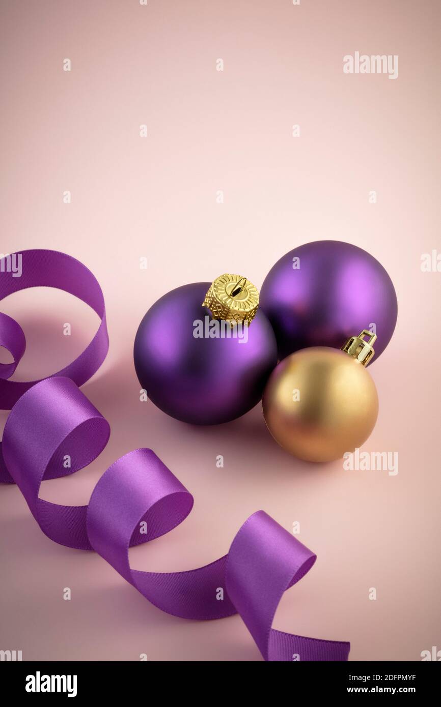 Purple and yellow Christmas baubles and purple ribbon Stock Photo
