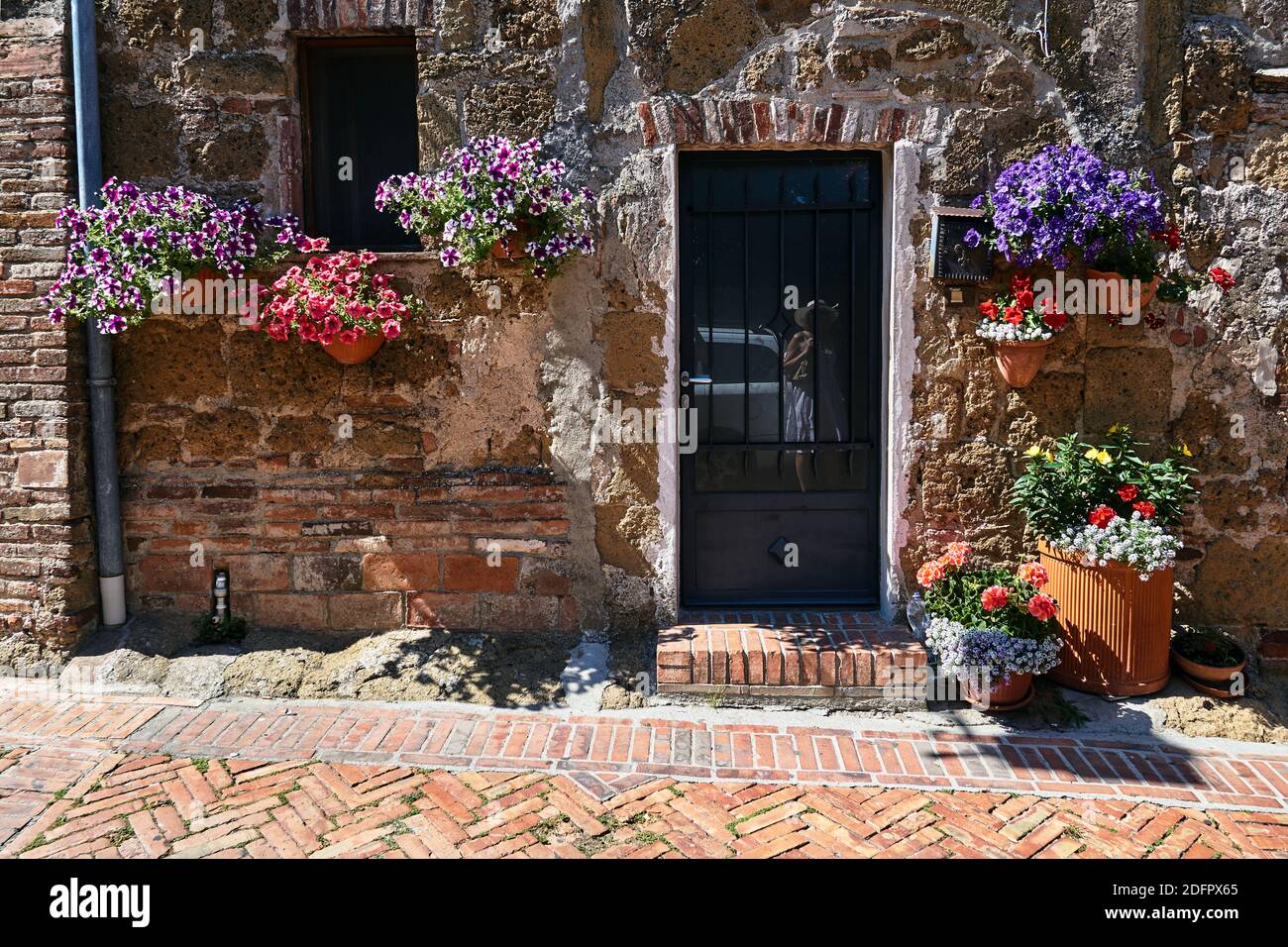 Flower pots with colorful flowers on the stone wall of a historic house ...