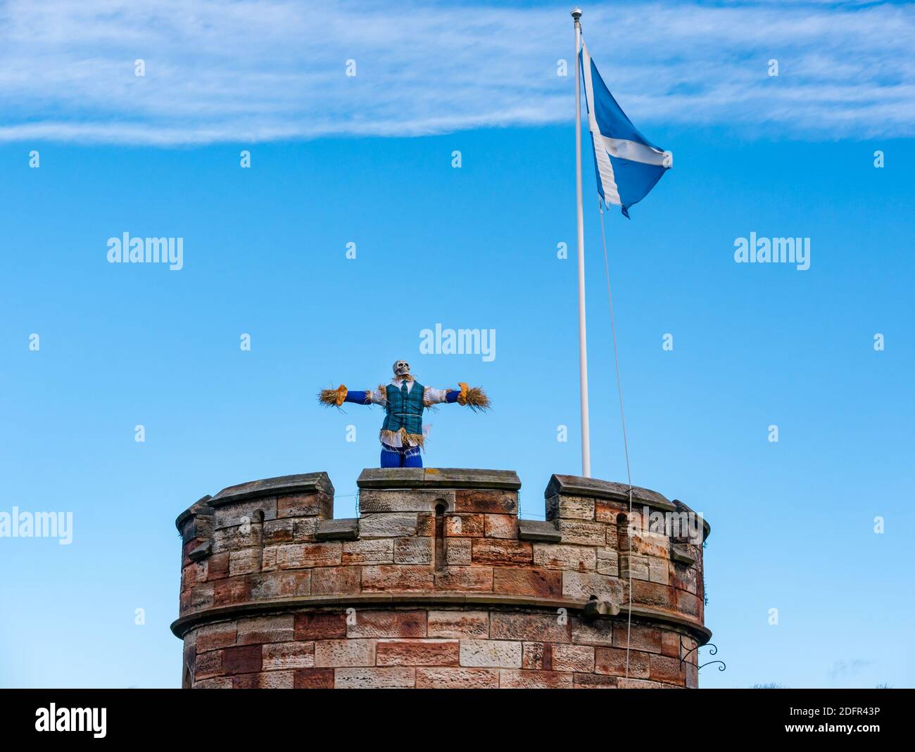 Quirky scarecrow with skull face on top of round tower with saltire flag, Dirleton Castle, East Lothian, Scotland, UK Stock Photo