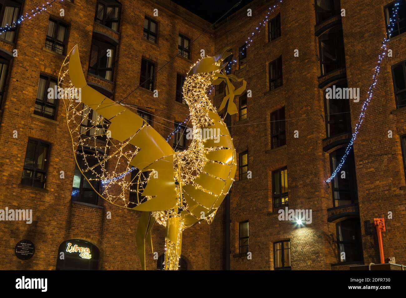 A massive golden Liverbird decorated in festive lights seen outside the Albert Dock in Liverpool just before Christmas in 2020.  This particular examp Stock Photo