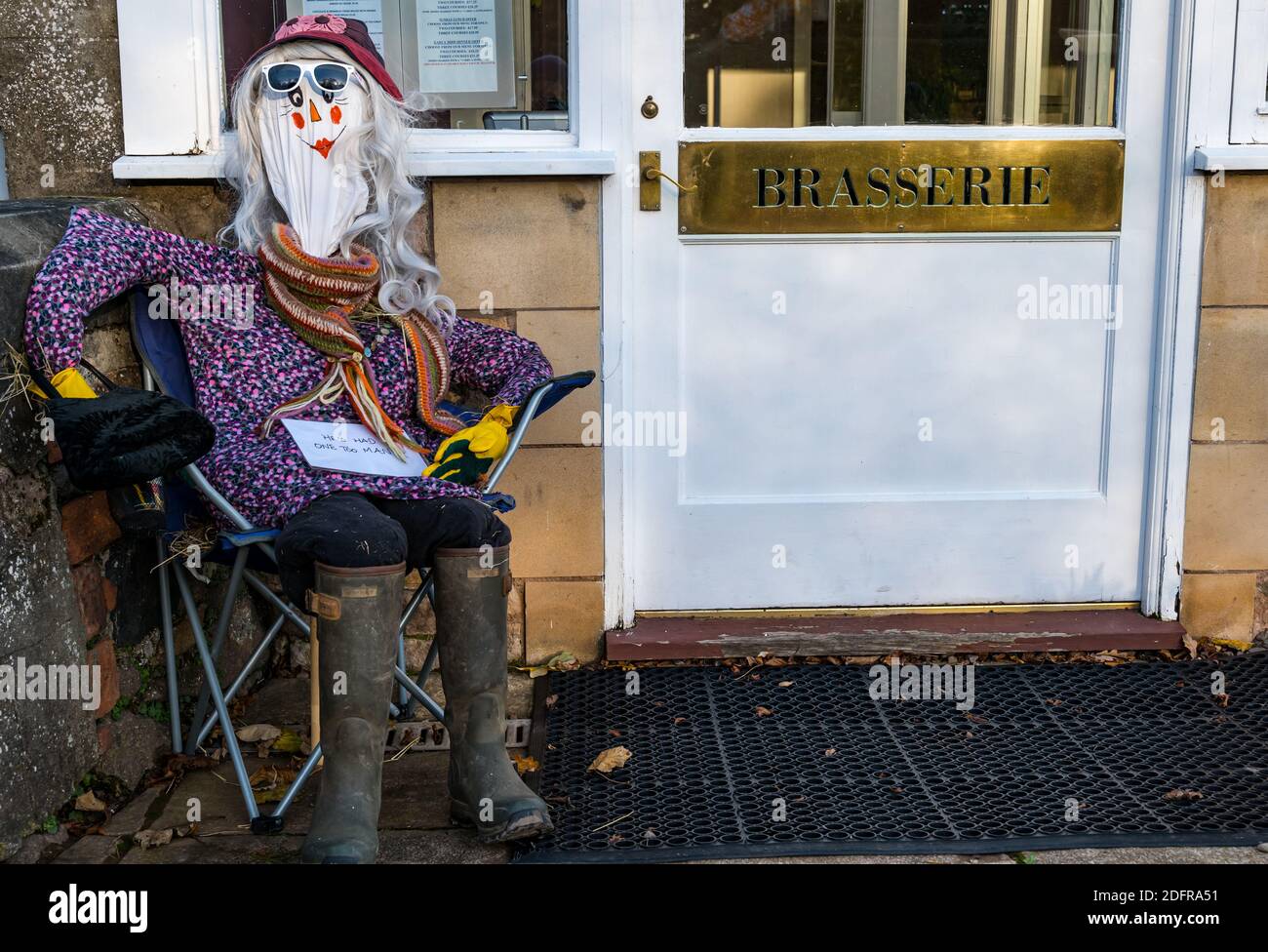 Quirky scarecrow sitting outside Open Arms Hotel brasserie, Dirleton, East Lothian, Scotland, UK Stock Photo