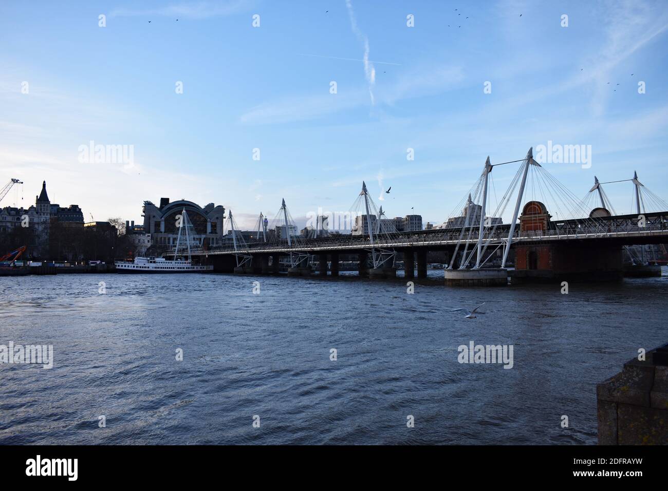 Looking across the River Thames from the Southbank to Embankment.  The Golden Jubilee bridge and Hungerford bridge lead  to Charing Cross Station. Stock Photo