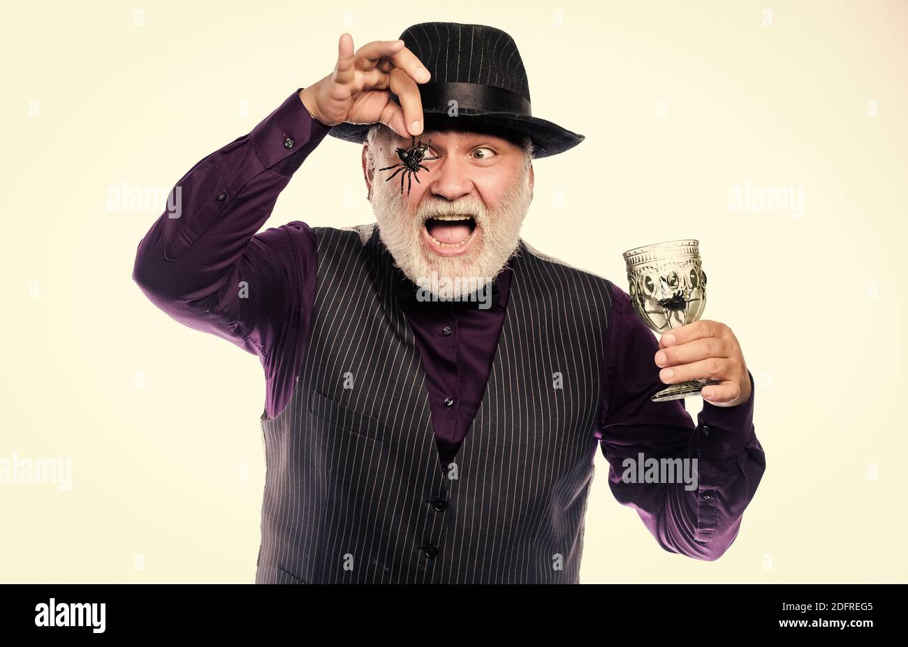 Halloween night. halloween holiday costume. barman make cocktail for halloween party. mature man magician in witch hat. happy halloween. evil wizard cooking magic potion with spider. Stock Photo