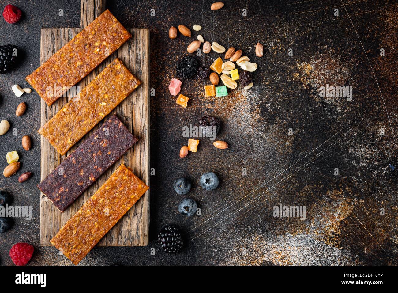 Dried fruits energy bars, top view with copy space, on old dark table