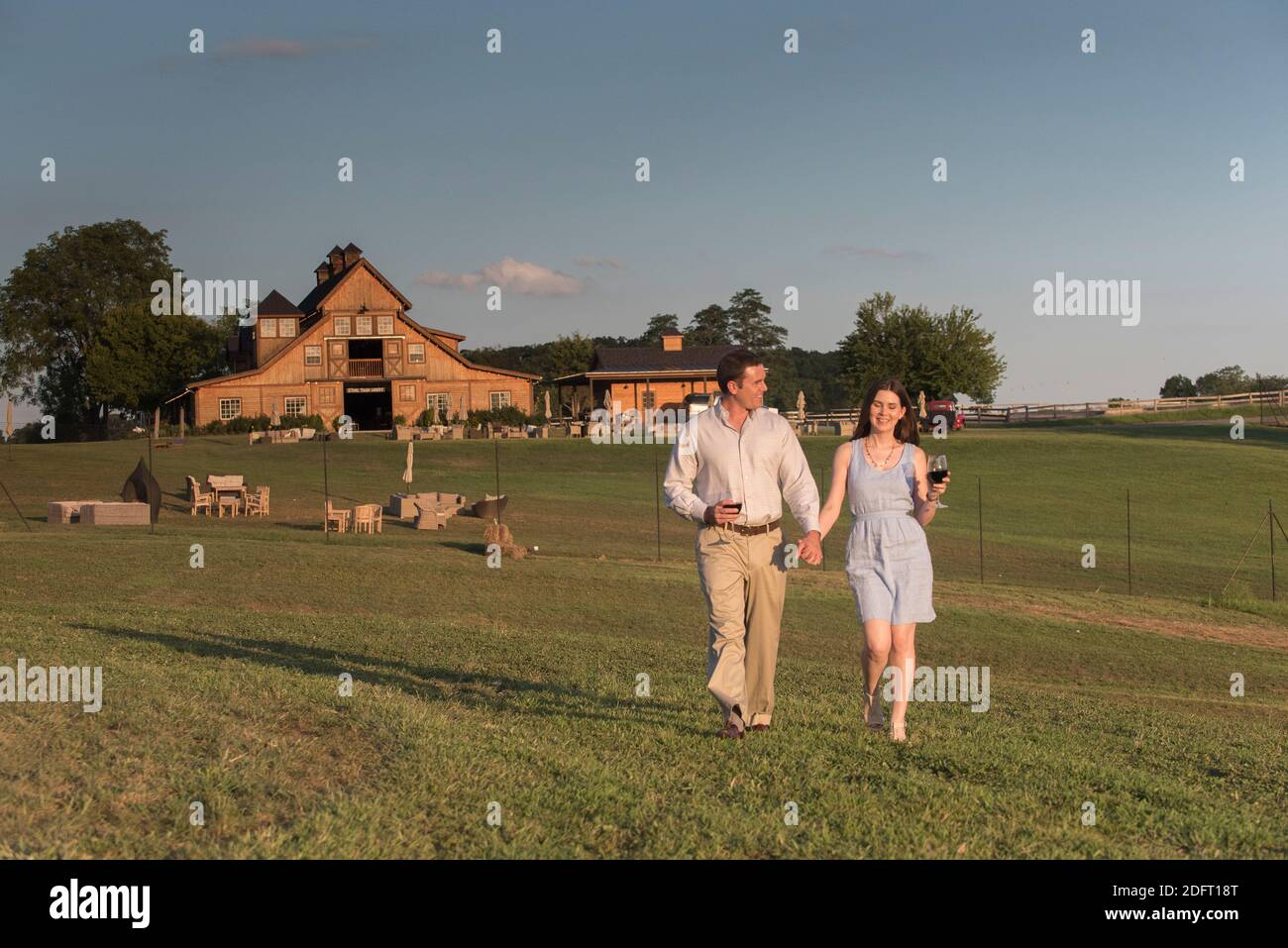 A young couple walks hand-in-hand at a winery. Stock Photo