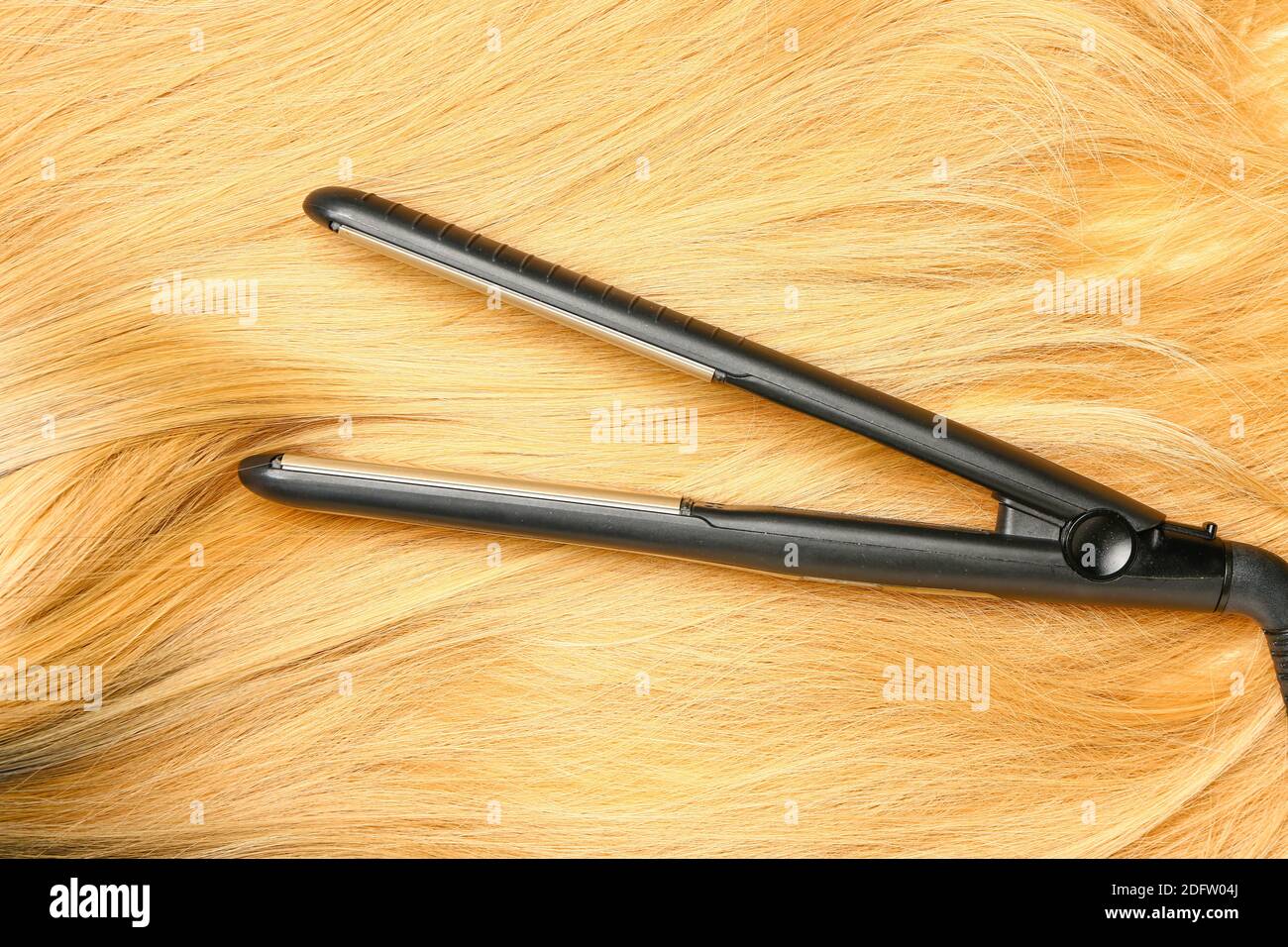 Straightening iron with color hair Stock Photo Alamy