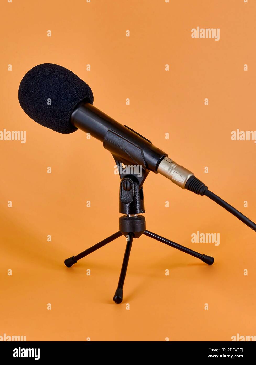 Dinamic microphone on a tripod table stand with protective sponge. Stock Photo
