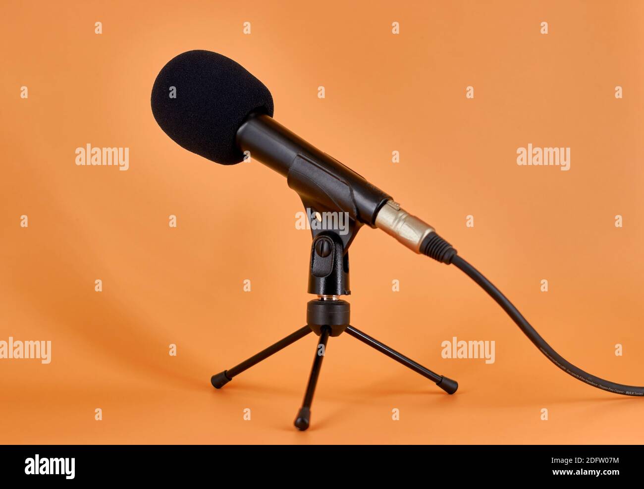 Dinamic microphone on a tripod table stand with protective sponge. Stock Photo