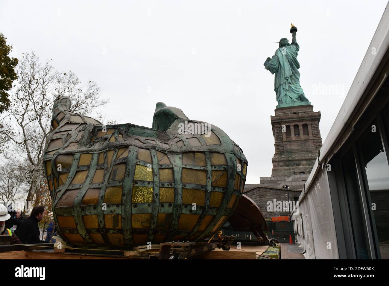 Workers transport the Statue of Liberty original torch along with a replica of the statue's face