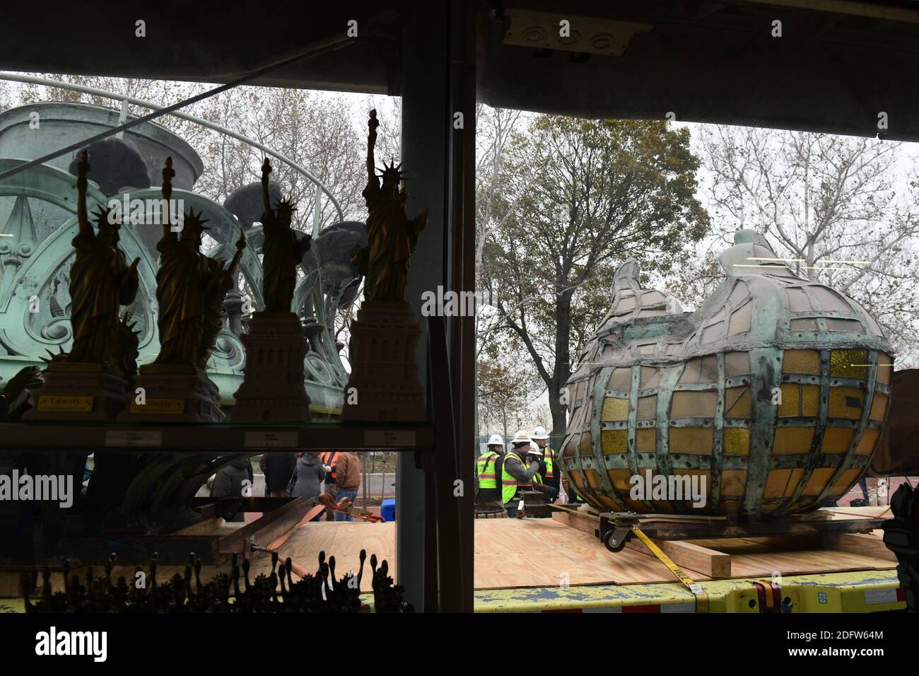 Workers transport the Statue of Liberty original torch along with a replica of the statue's face
