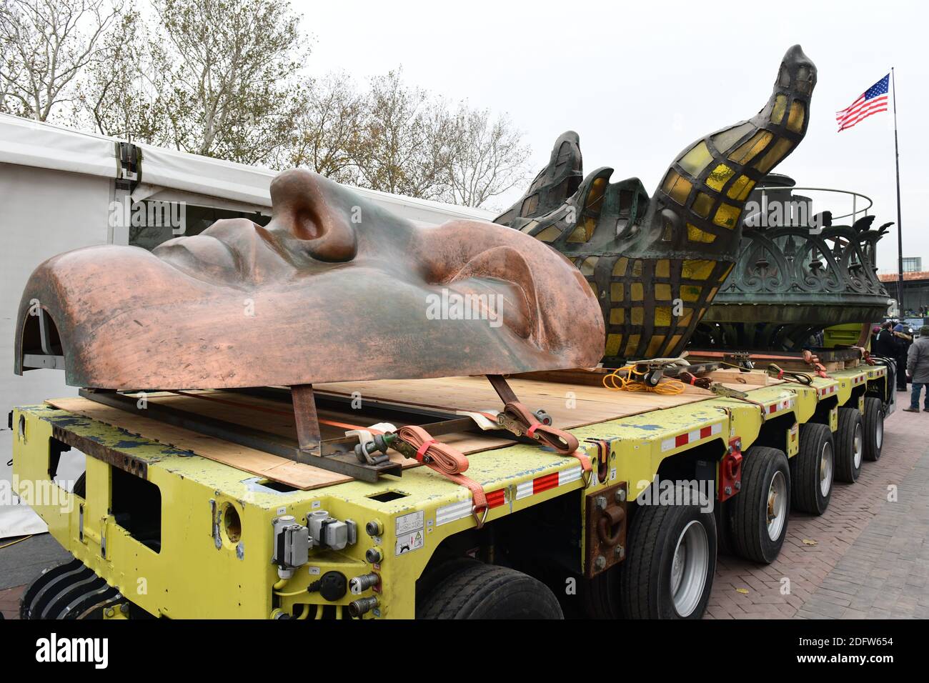 Workers transport the Statue of Liberty original torch along with a replica of the statue's face