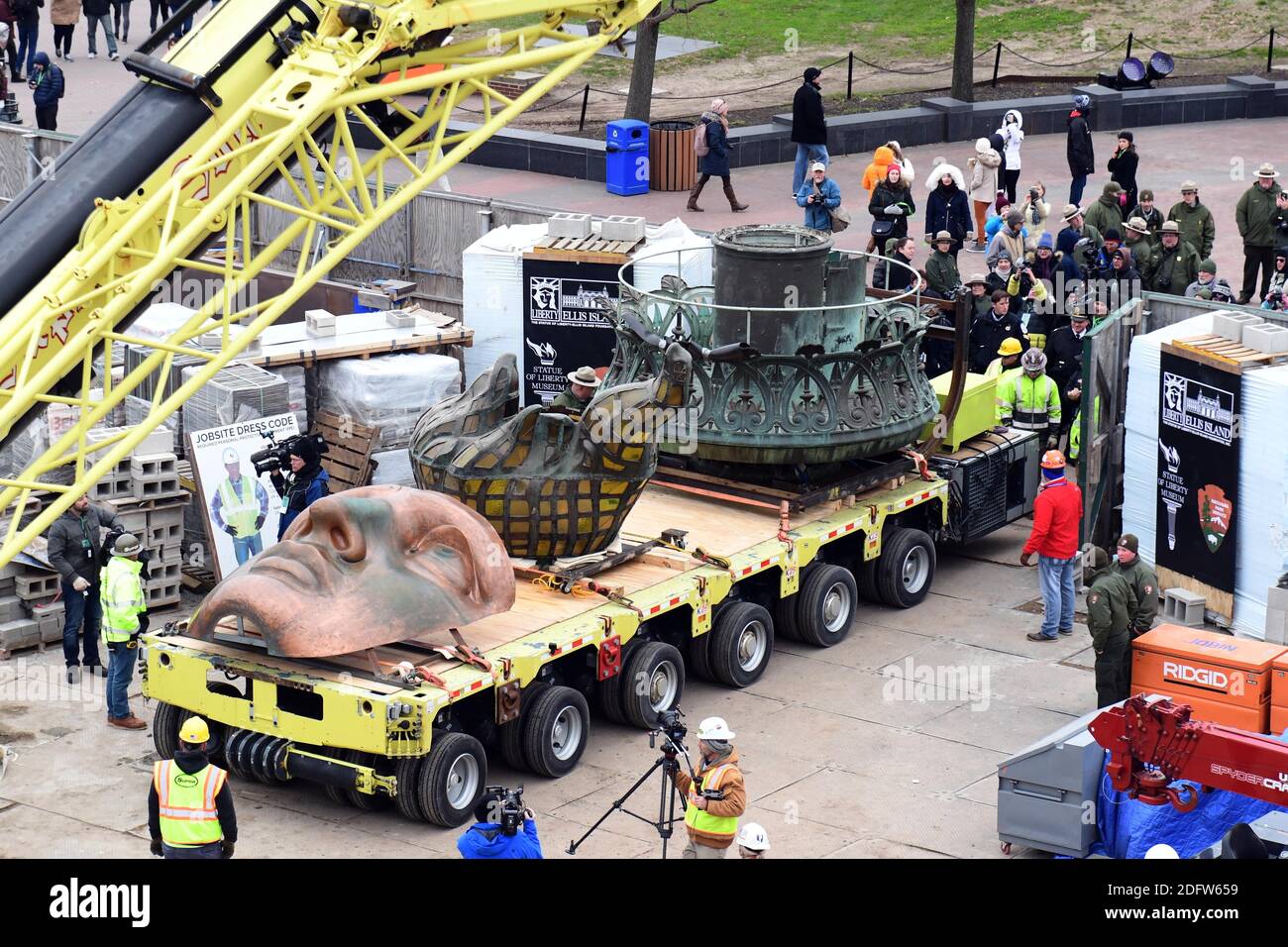 Workers transport the Statue of Liberty original torch along with a replica of the statue's face