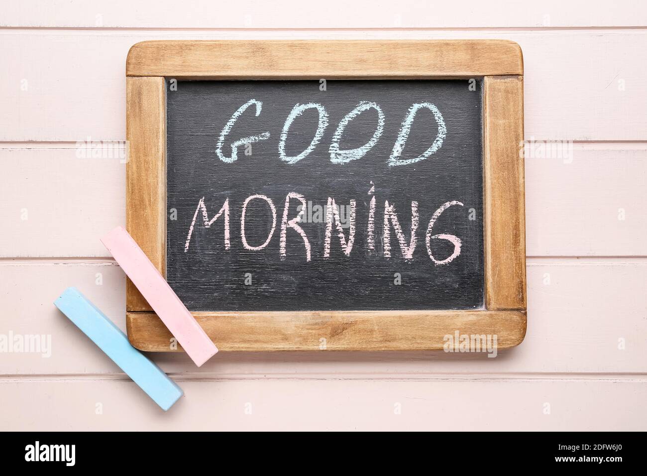 Colorful chalks and chalkboard with text GOOD MORNING on wooden ...