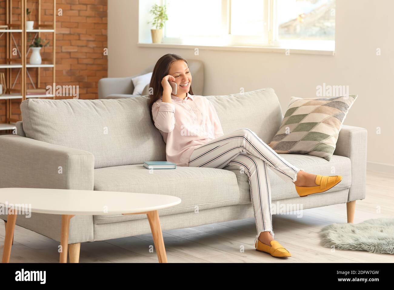 Cute teenage girl with mobile phone at home Stock Photo - Alamy