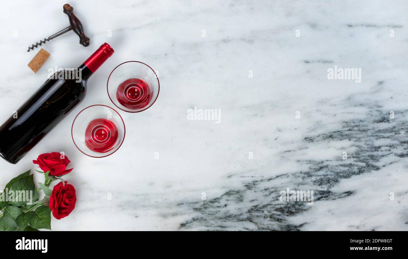 Red wine and corkscrew opener for a Happy Valentines Day on marble stone background setting Stock Photo