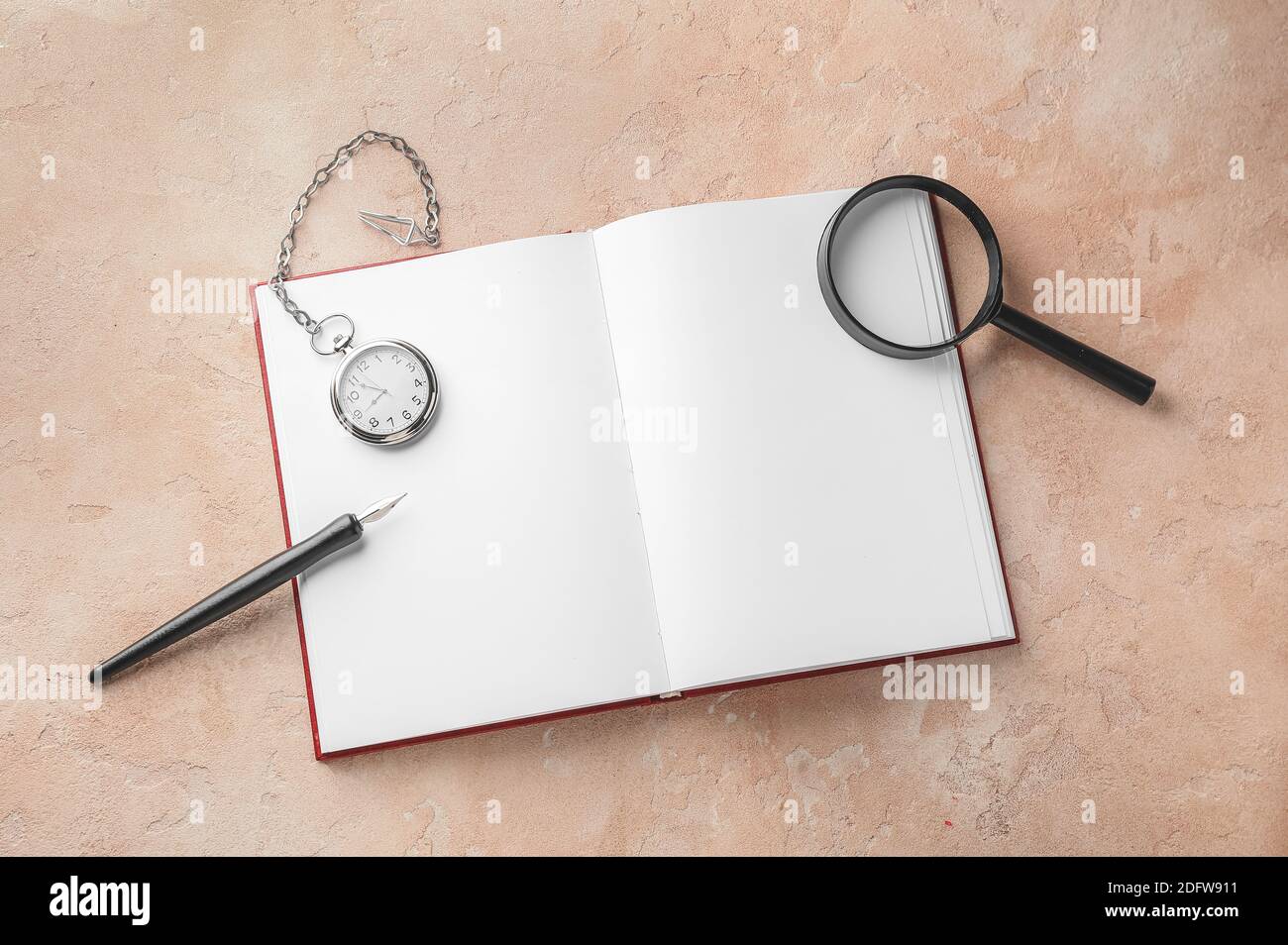 Notebook, pocket clock, magnifier and nib pen on table Stock Photo