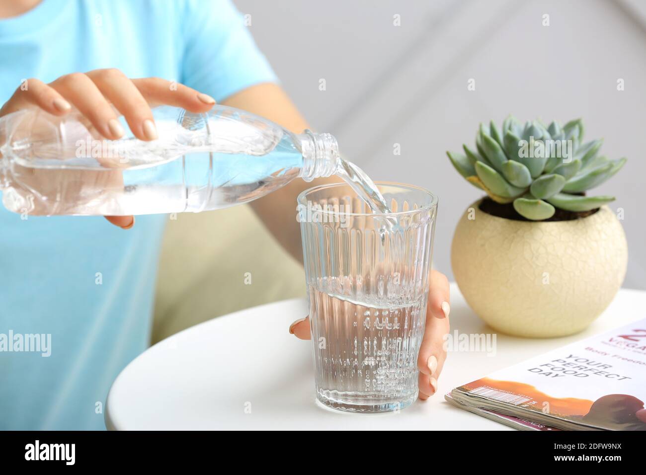 https://c8.alamy.com/comp/2DFW9NX/woman-pouring-water-from-bottle-into-glass-on-table-closeup-2DFW9NX.jpg