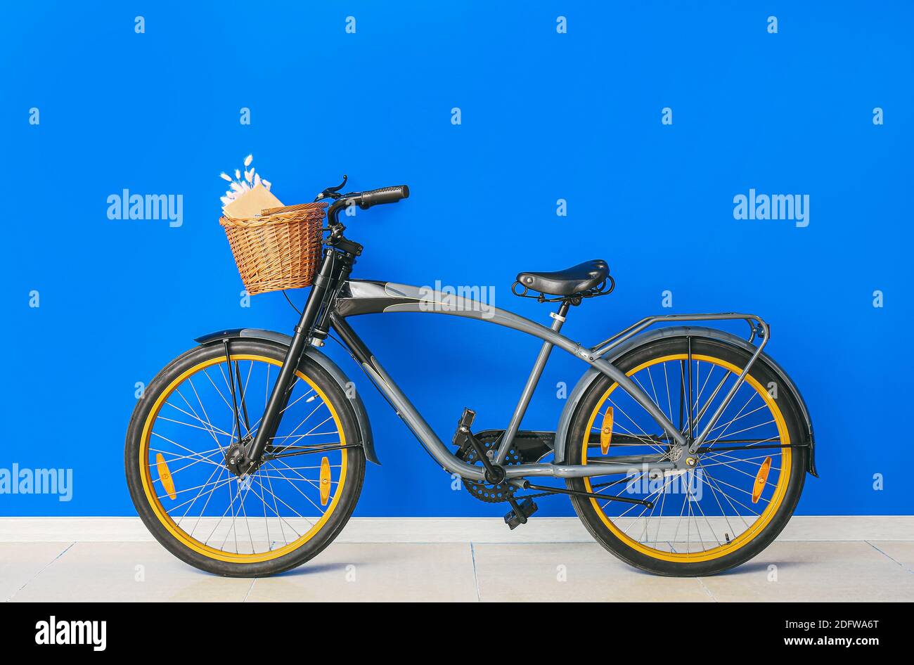 Modern bicycle with basket against color wall Stock Photo Alamy