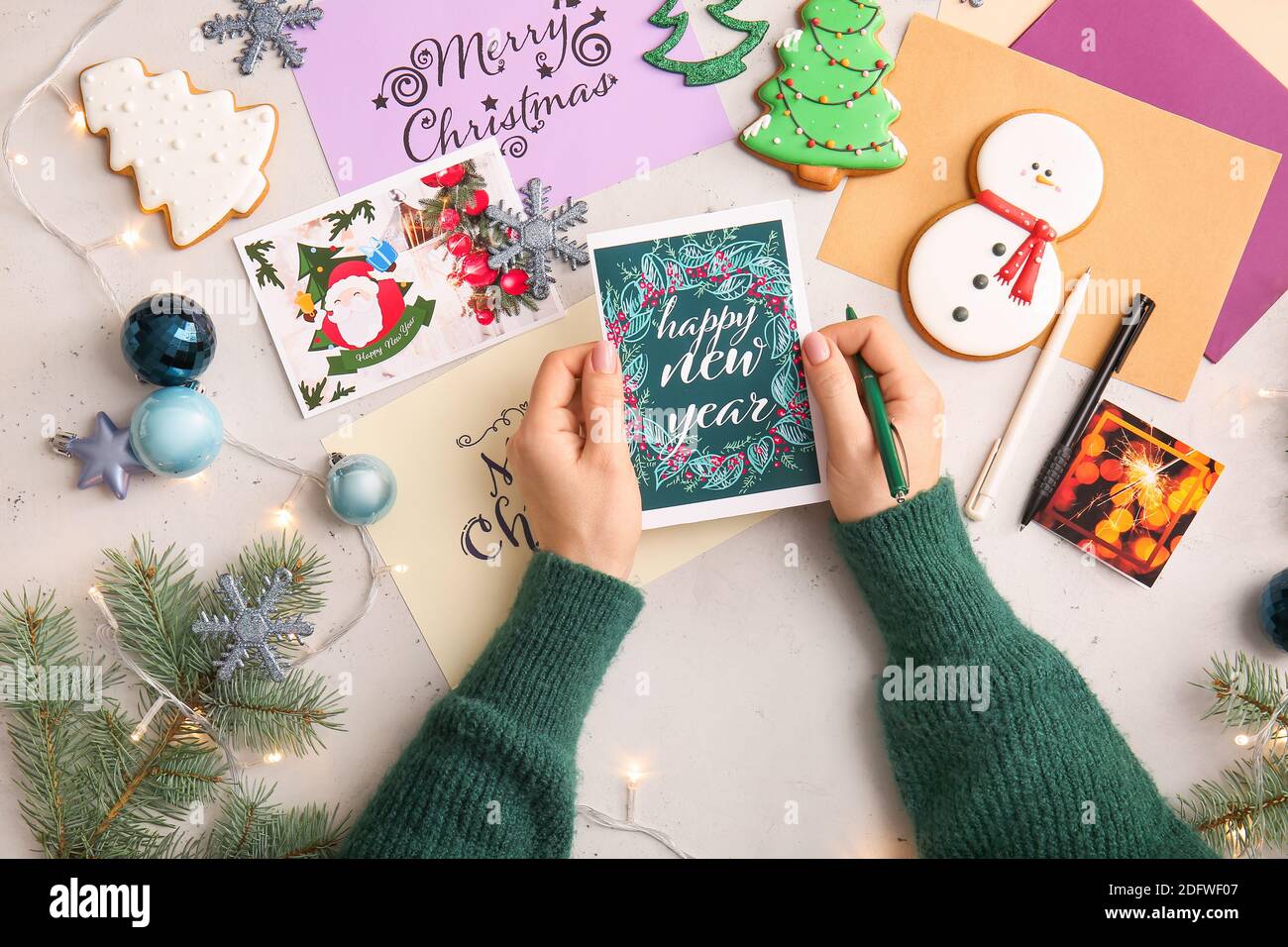 Woman writing greeting postcards for Christmas and New Year