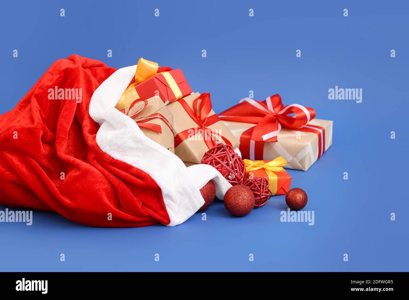 Santa Claus bag full of gifts on color background Stock Photo - Alamy