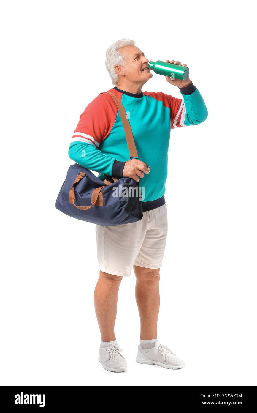 Sporty senior man with bag and bottle of water on white background ...