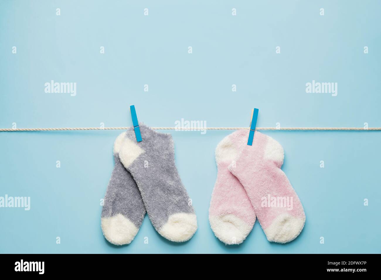 Rope with warm socks on color background Stock Photo - Alamy