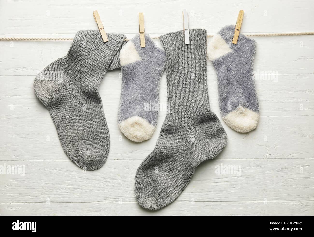 Rope with warm socks on white background Stock Photo - Alamy