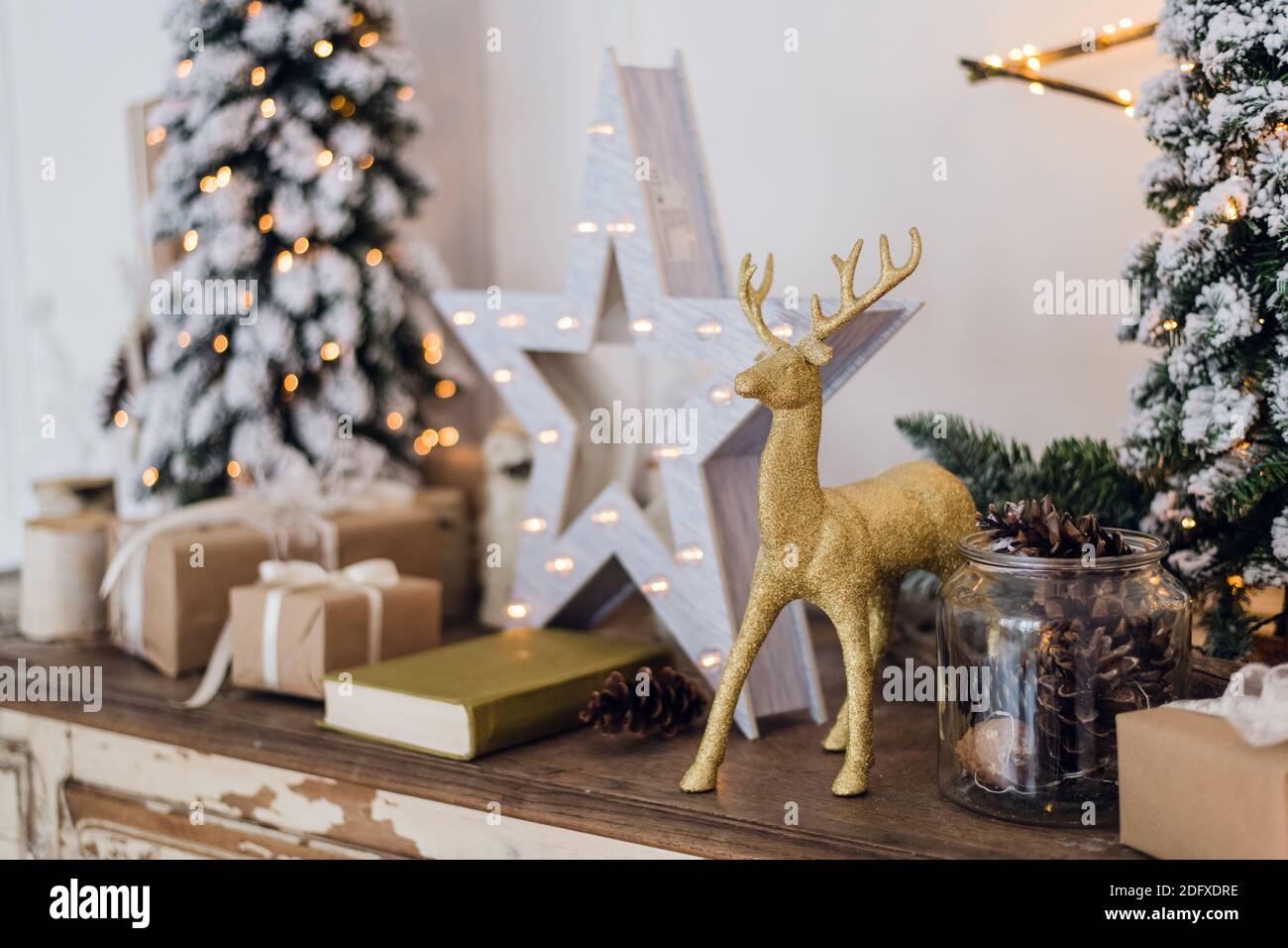 winter still life with Christmas decorations toy deer, star and gift boxes on light background. soft focus, blurred background Stock Photo