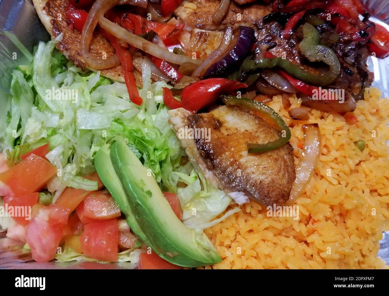 Grilled tilapia with yellow rice, fried onions, lettuce, chopped