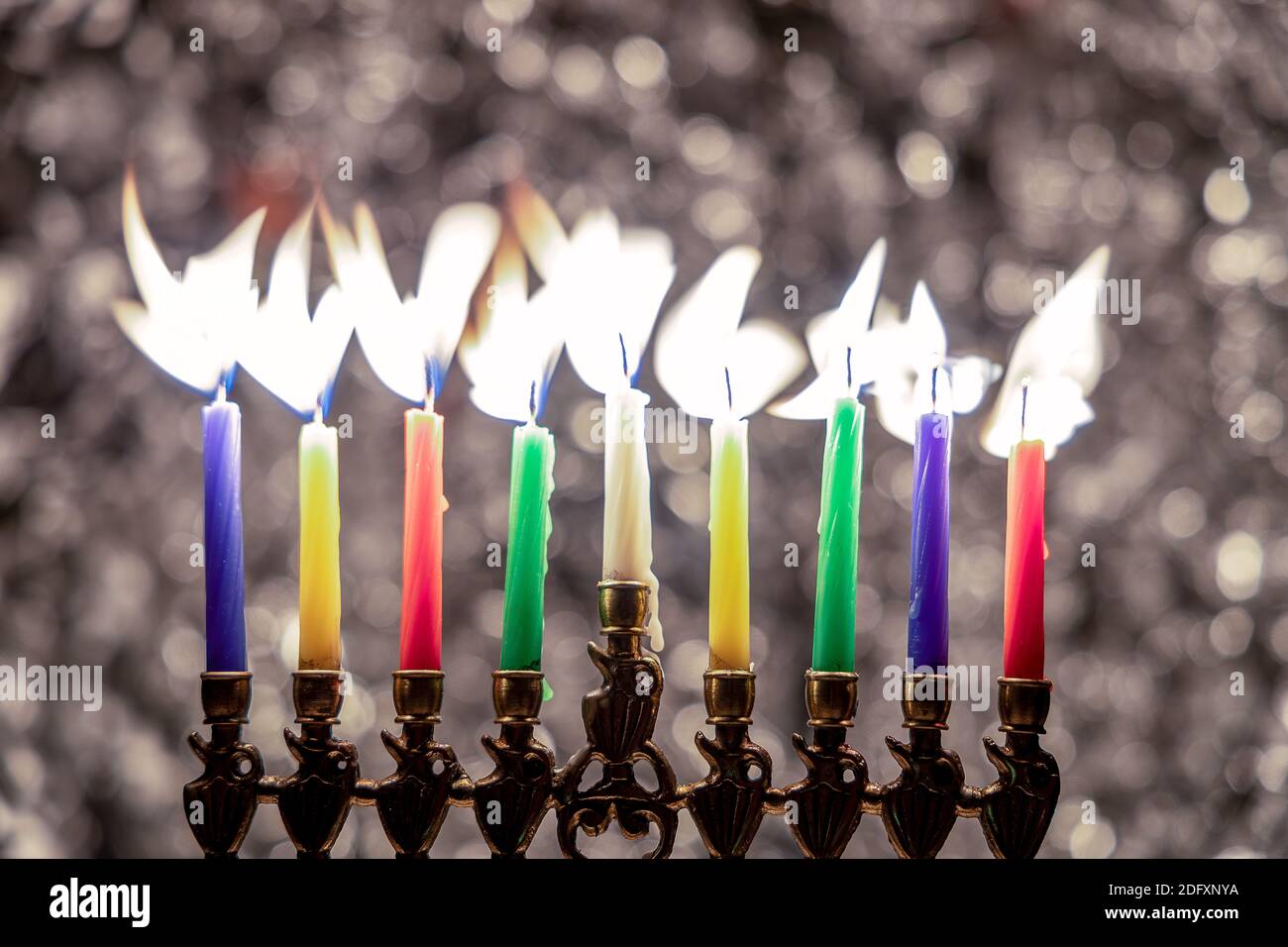 Menorah with candles for Hanukkah celebration over bokeh background Stock Photo