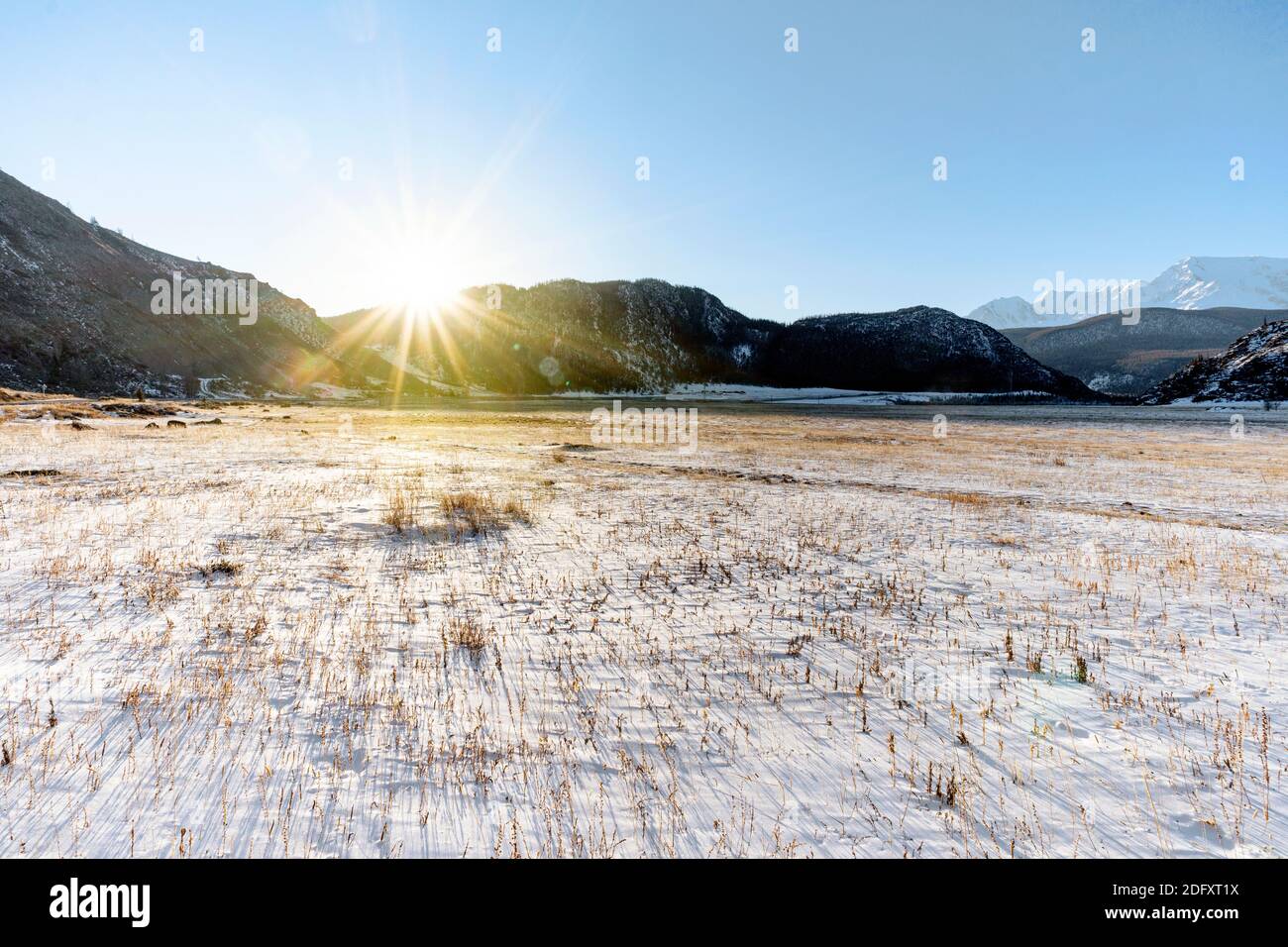 Early morning sunrise in steppes. Snow-covered pasture in the Altai Republic. The onset of winter, snow cover. Severe frost. Stock Photo