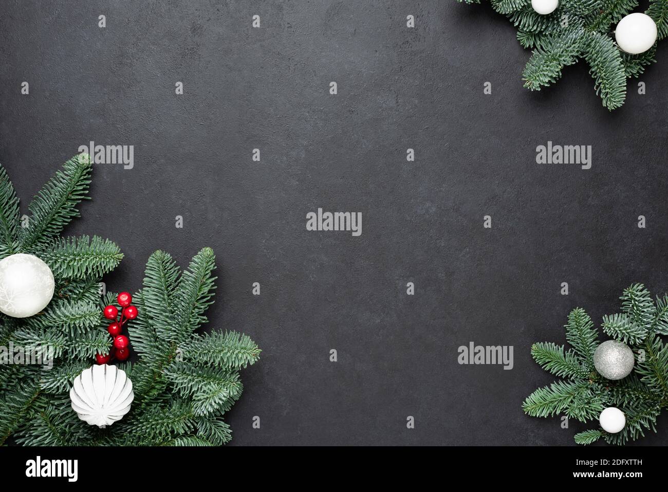 Christmas frame with fir tree on black concrete background. Top view copy space Stock Photo