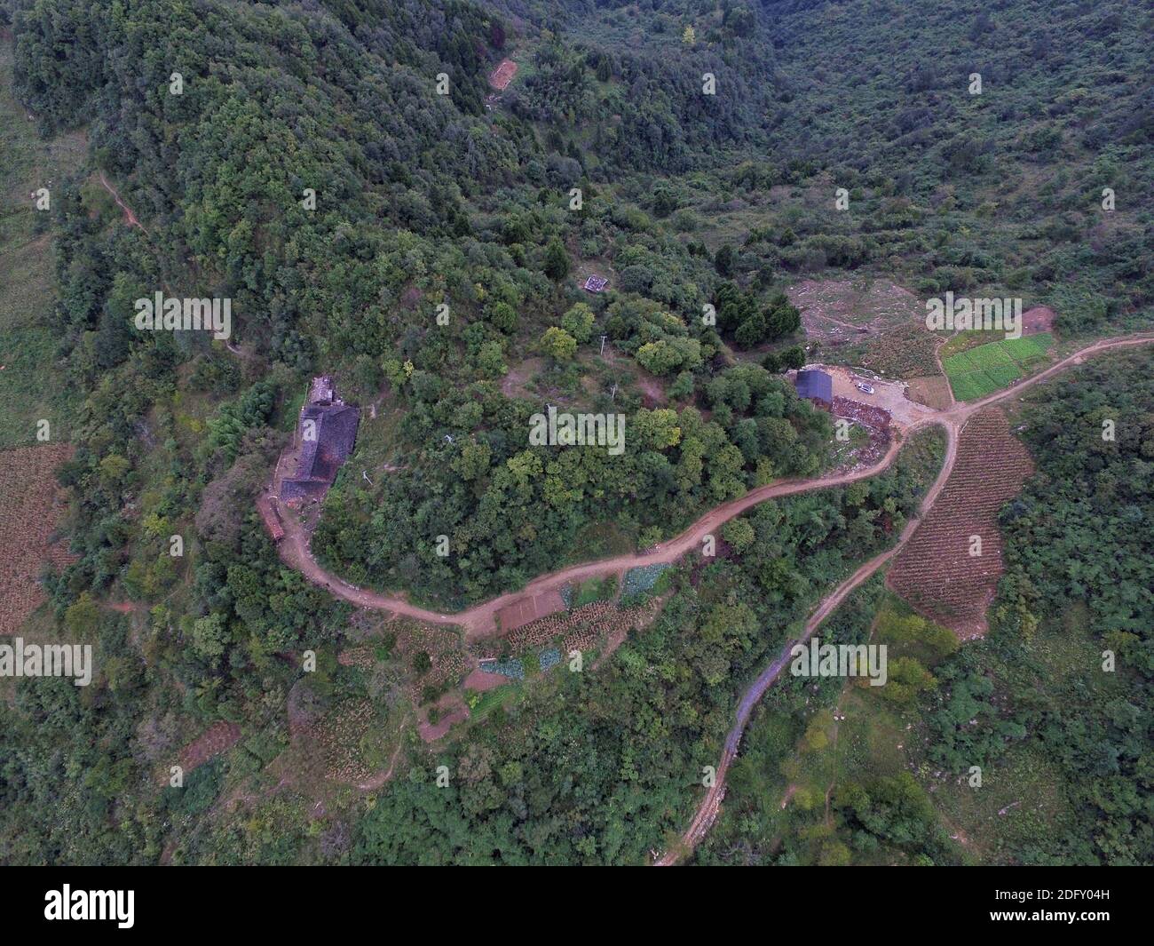 (201205) -- CHENGDU, Dec. 5, 2020 (Xinhua) -- Aerial photo shows Li Guozhi's old residence (L), a ground flattened by him, and a downhill path he made in Xiaoluoma Village, Nuoshuihe Township, Tongjiang County, southwest China's Sichuan Province, Sept. 22, 2016. Xiaoluoma is a village tucked away in the Qinling-Daba mountain areas of southwest China's Sichuan Province. For years, the villagers here had been living in poverty. In 2015, China's central government launched a 'precision poverty relief' campaign which targeted such villages as Xiaoluoma. Since then a bunch of policies, including sm Stock Photo