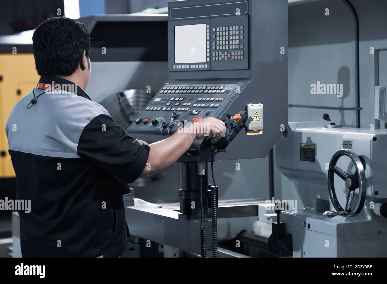 Industrial technician operating CNC lathing machine. Metalworking