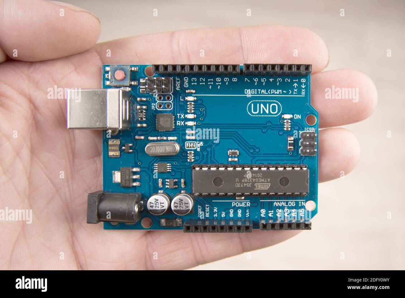 Arduino Uno board electronics in hand for programming the microcontroller Stock Photo