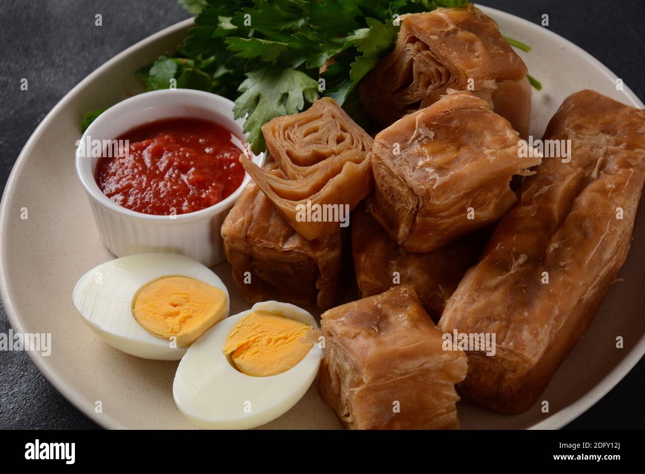 Jachnun or Jahnun, Yemenite Jewish pastry, served with fresh grated tomato and boiled egg and