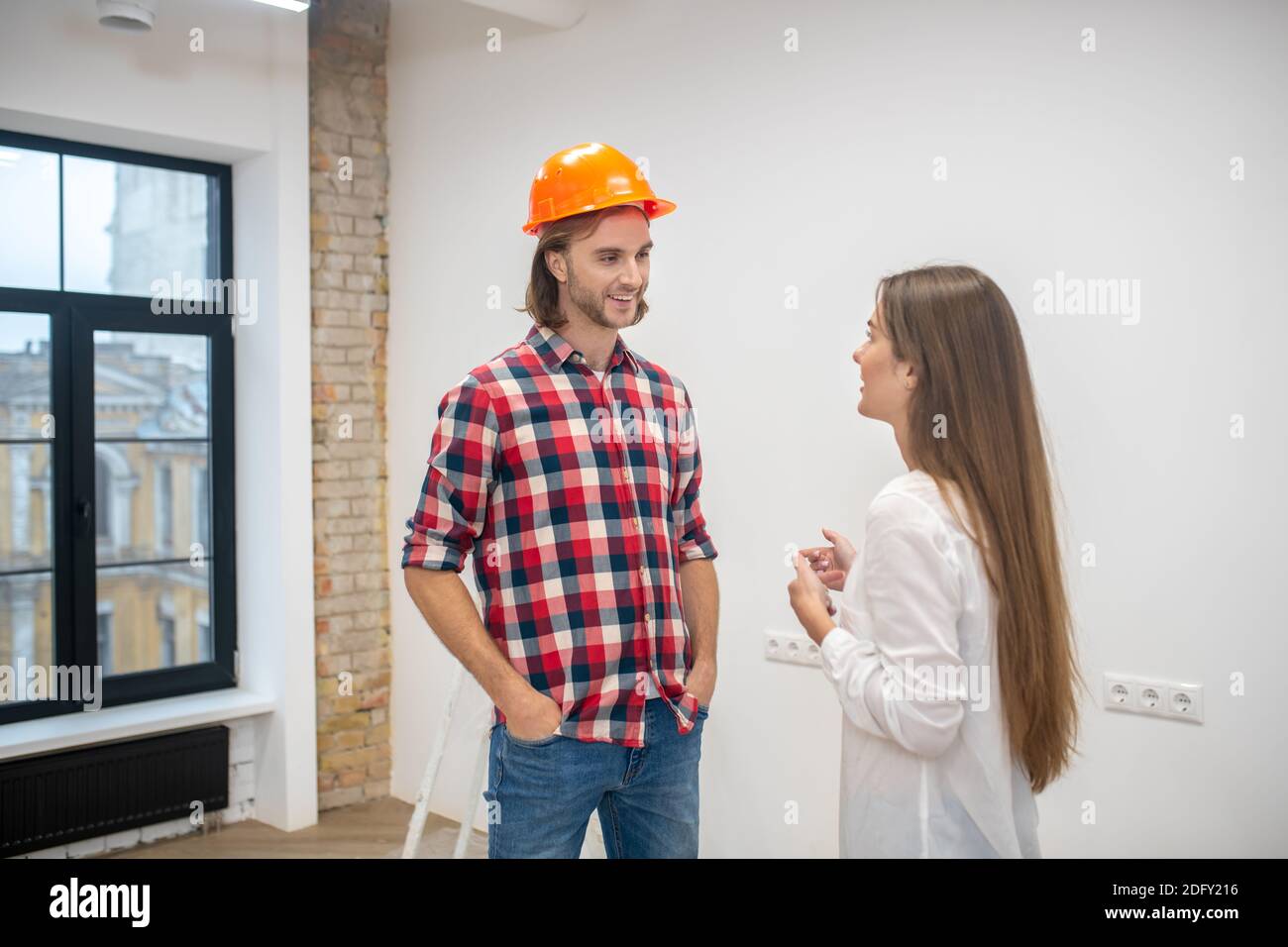 Female purchaser talking to the construction worker Stock Photo