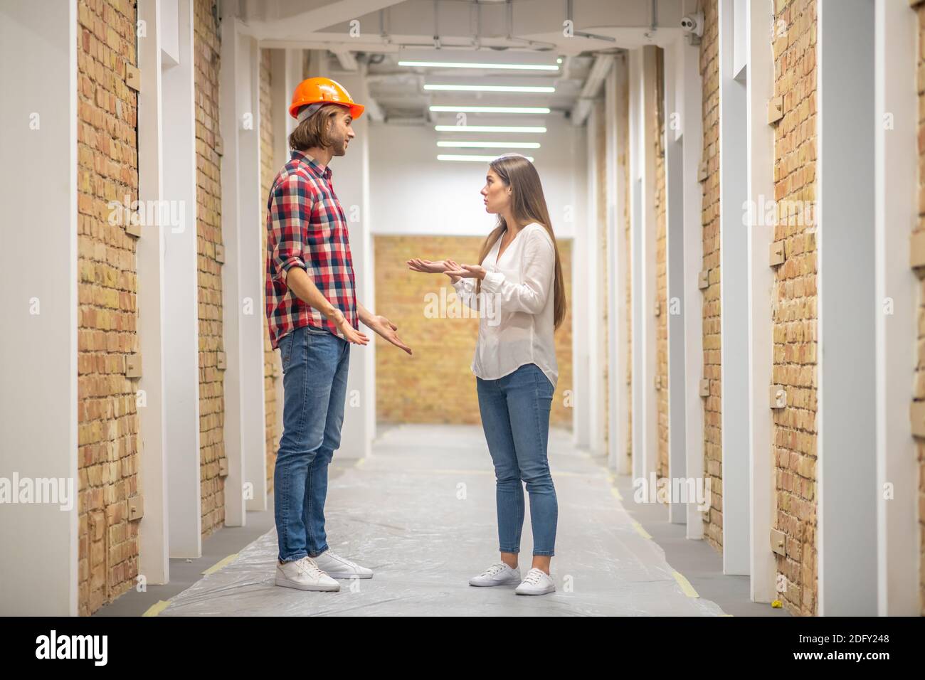 Female purchaser discussing construction issues with the worker Stock Photo