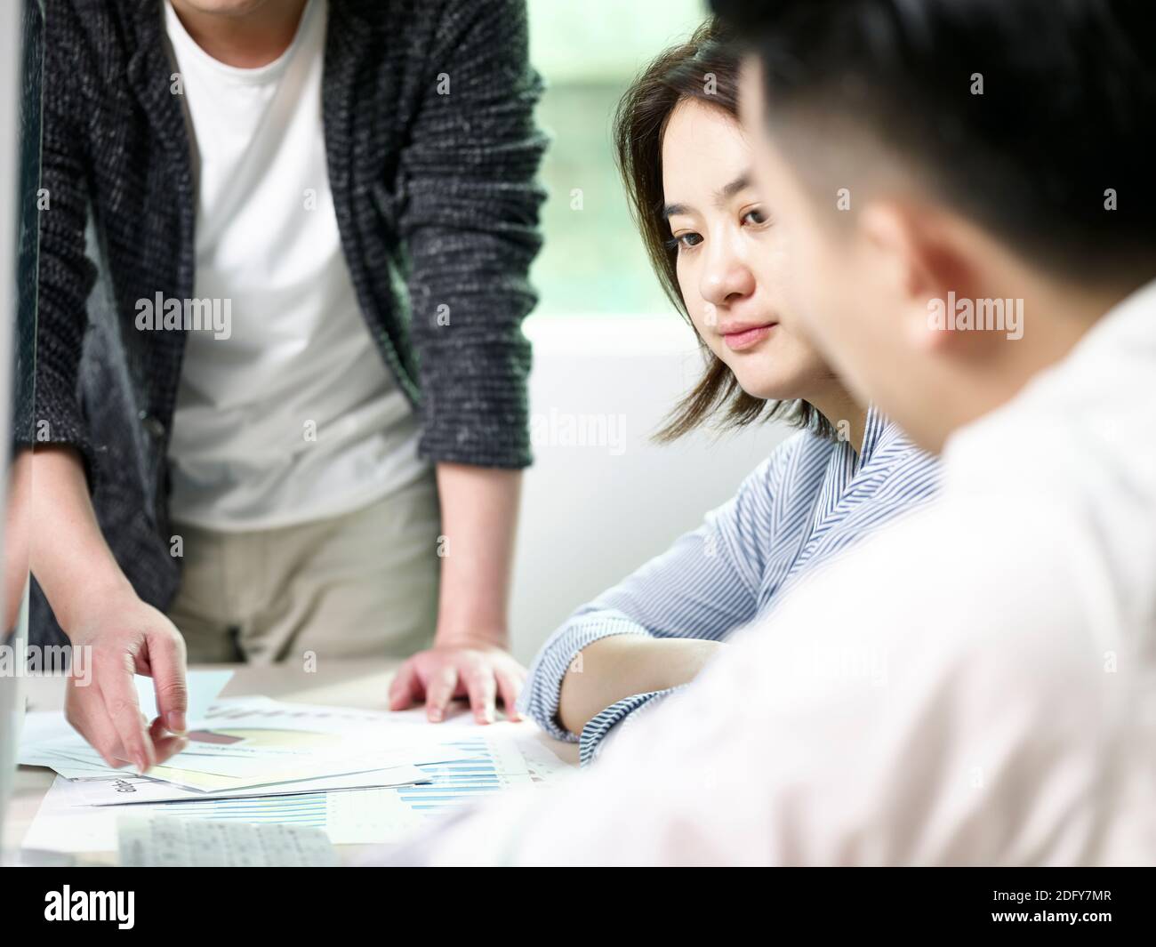 young asian business woman contemplating during meeting in office with two colleagues Stock Photo